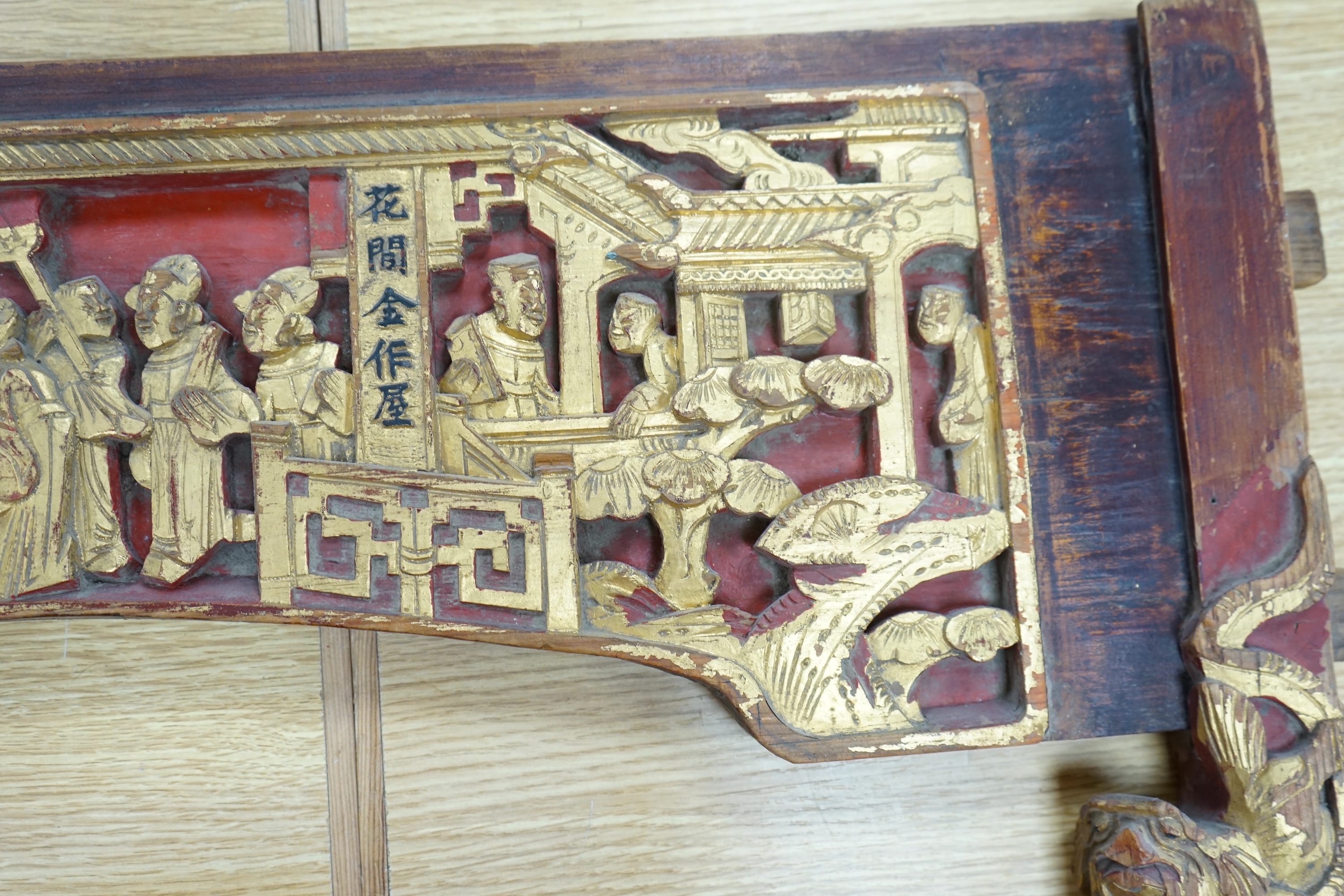 A Chinese carved figural gilt wood and stained arched panel, 94cm wide. Condition - worn with age and use